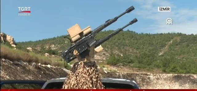 برج درع المسيّرات في اختبار بوران-8 الميداني: بندقيتان نصف آليتان ووحدة مستشعر Lasersan الكهروبصري على مركبة مغطاة بشبكة تمويه، موجّهتان نحو سماء زرقاء.
